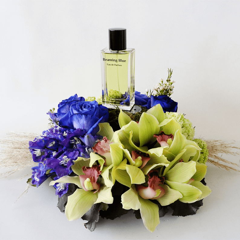 Beaming Blue 1_2 Cymbidium orchids with blue rose and delphinium in an arrangement with beaming blue perfume