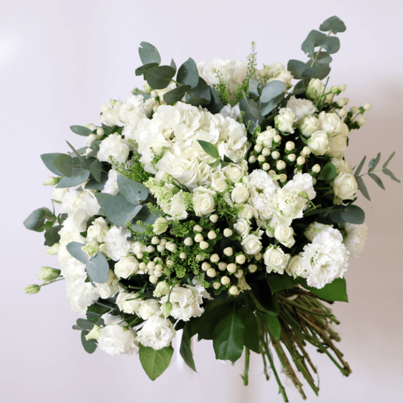 White and green bouquet white hydrangea, white spray roses, white hypericum and eustoma in a bouquet