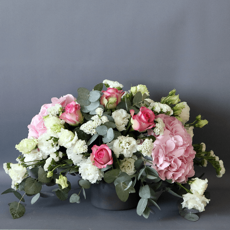 pink and white arrangement pink roses, pink hydrangea, white statice and eustoma arranged in a ceramic vase