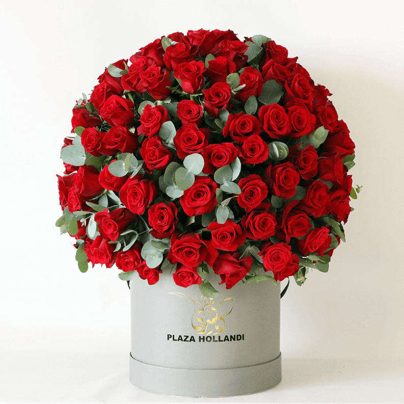 round red rose arrangement in a hat box red roses arranged in a round design with eucalyptus in a Plaza Hollanndi hat box
